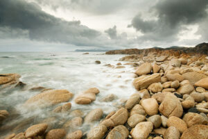 photograph of the sea meeting a rocky shoreline